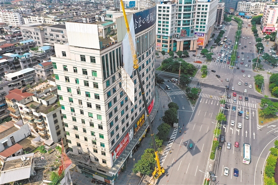 由于要拆除的廣告牌在樓頂，工作人員動(dòng)用75米高的吊機(jī)進(jìn)行作業(yè)。