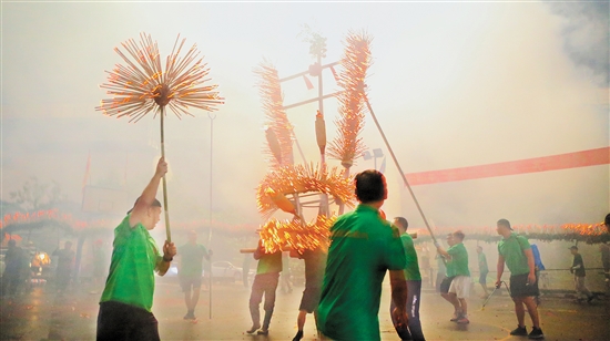 伴隨著鑼鼓聲，北坎村點(diǎn)燃香枝的火龍正在追逐“龍珠”。