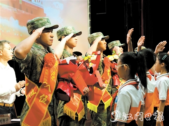 小學(xué)生代表向入伍新兵代表獻(xiàn)上鮮花。