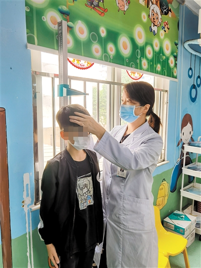 醫(yī)生為兒童量身高。