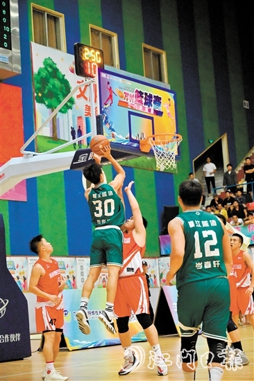 萬(wàn)村籃球賽江門(mén)市級(jí)賽決賽現(xiàn)場(chǎng)，橫江村隊(duì)隊(duì)員迎著防守跳投得分。