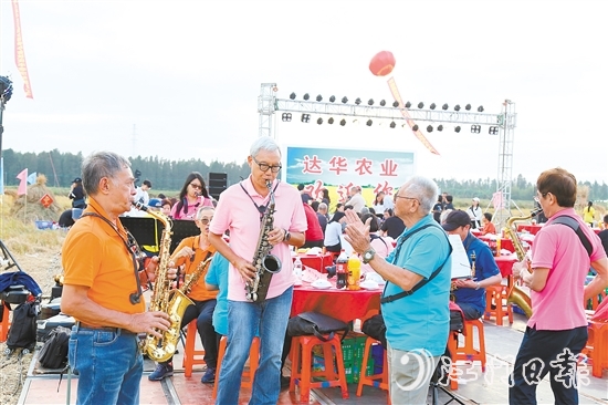 表演人員在稻田里吹響薩克斯風(fēng)，與澳門禮樂鄉(xiāng)親齊慶豐收。