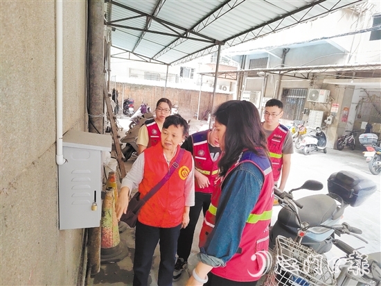 退休黨員干部鄧玉歡與網(wǎng)格員一起就充電樁選址開展調(diào)研。