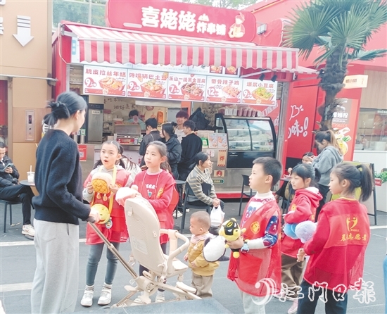 統(tǒng)一身著志愿者服裝的孩子們化身“愛心小掌柜”，向顧客推銷商品。