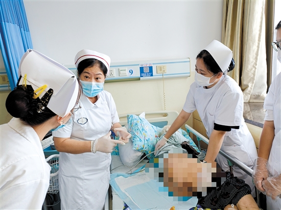 朱敏林（中）與同事對(duì)患者進(jìn)行護(hù)理服務(wù)。
