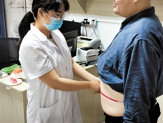 醫(yī)生為記者測(cè)量腰圍。