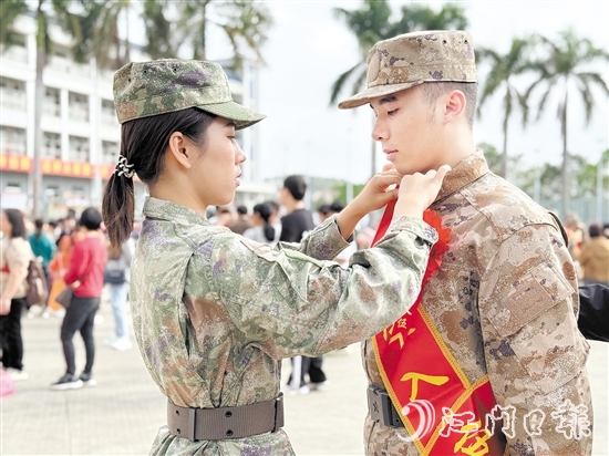 在歡送儀式現(xiàn)場，老兵姐姐為新兵弟弟整理軍裝。