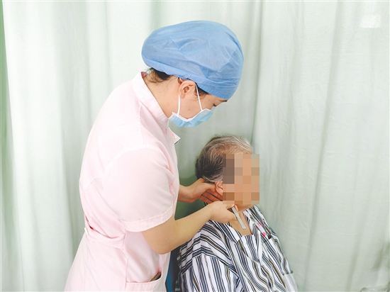 醫(yī)護(hù)人員為患者進(jìn)行中醫(yī)外治療法。