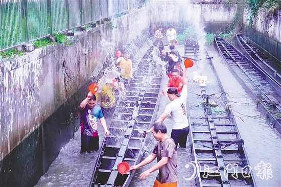 在水口鎮(zhèn)龍東村委會欖沖村，村民們合力將深埋河底的龍舟“喚醒”，為即將到來的端午龍舟賽事做準(zhǔn)備。