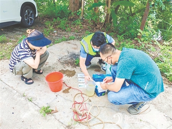 巡河過程中，工作人員沿河查看并采集水樣進(jìn)行檢測。