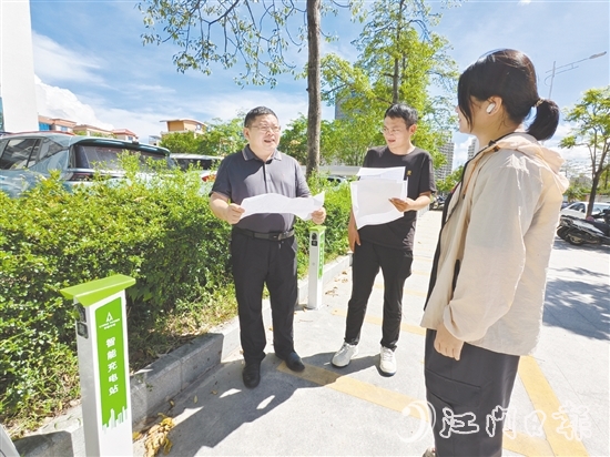 余中宏（左一）與同事一起查看“民生服務(wù)充電站”項目建設(shè)進度。