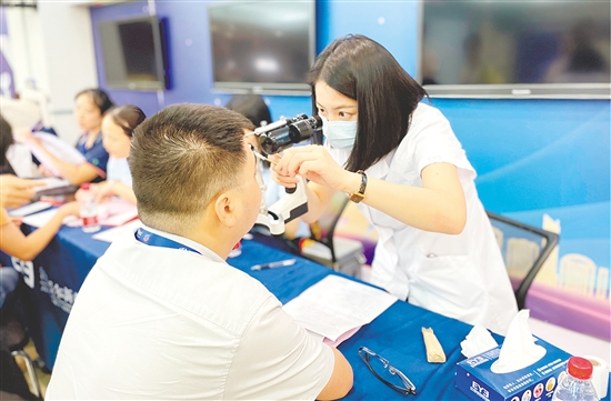 醫(yī)護人員為企業(yè)職工檢查眼睛。