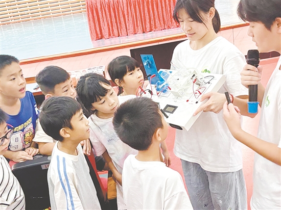 服務(wù)隊(duì)隊(duì)員向孩子們展示氫燃料電池演示儀。