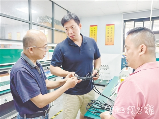 盧慶忠（中）與技術(shù)人員交流產(chǎn)品質(zhì)量問(wèn)題。