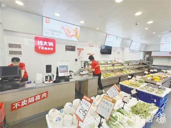 錢大媽生鮮店的工作人員正在線上接單并準(zhǔn)備菜品。