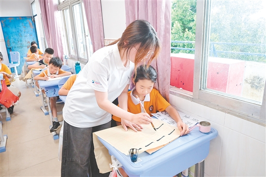 社會(huì)實(shí)踐隊(duì)隊(duì)員指導(dǎo)學(xué)生練習(xí)硬筆、軟筆書法。
