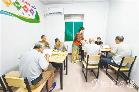 老人在助餐點享用熱氣騰騰的飯菜。