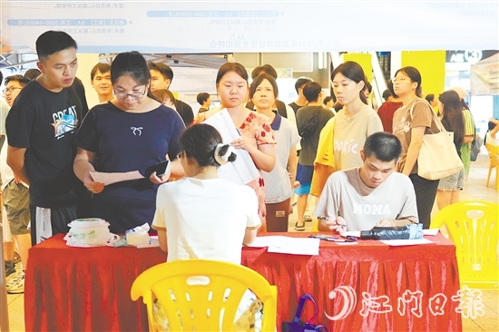 活動現(xiàn)場，求職者手持簡歷與企業(yè)招聘人員進(jìn)行交流。