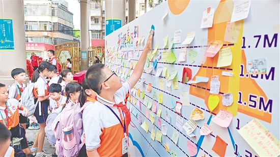 沙坪街道第一小學(xué)設(shè)立“開(kāi)學(xué)摸高簽到墻”，學(xué)生貼上寫(xiě)有新學(xué)期愿望的“心愿卡”。