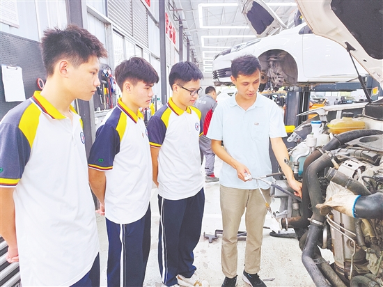 黃永健（右一）在指導(dǎo)學(xué)生實(shí)訓(xùn)。