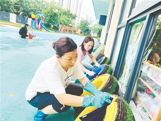 蓬江區(qū)實驗幼兒園的老師們把教學道具輪胎放在避雨處，并清理積水。