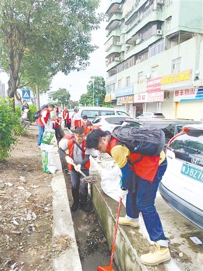 黨員防疫突擊隊隊員在開平市長沙街道南島社區(qū)清理垃圾。
