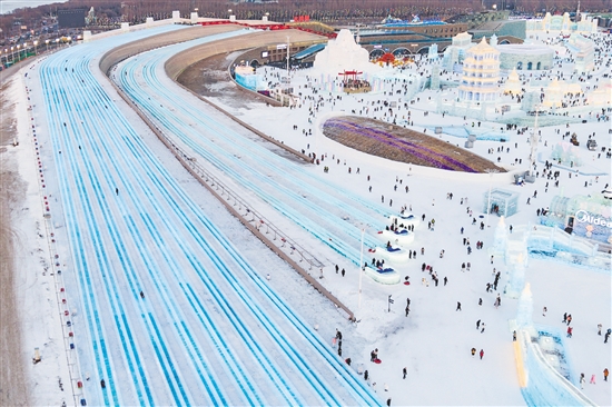 圖為當(dāng)日，游客在哈爾濱冰雪大世界園區(qū)體驗(yàn)“超級(jí)冰滑梯”（無(wú)人機(jī)照片）。新華社發(fā)
