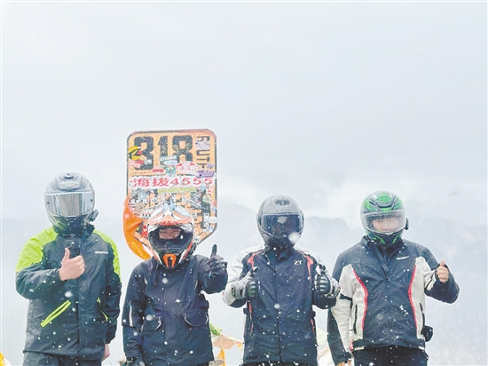 余鴻威（右一）與“旅游搭子”騎摩托車到西藏途中合影留念。