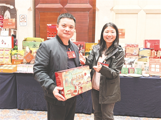 盧子策（左）熱情推介家鄉(xiāng)特色農(nóng)產(chǎn)品。