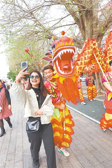 春節(jié)期間，江南路金龍巡游，吸引市民駐足合影。
