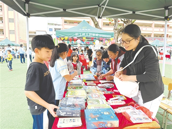 作為“顧客”的學(xué)生穿梭在各個攤位之間，認(rèn)真挑選心儀的物品。