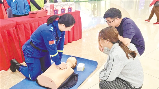 志愿者向市民示范心肺復蘇等急救技能的操作要領。