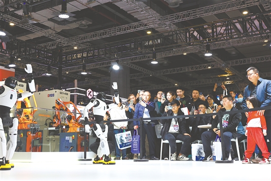 圖為當日，參觀者在展會現(xiàn)場觀看人形機器人舞蹈表演。新華社發(fā)