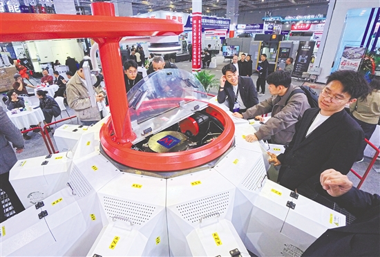 圖為當日，參觀者在一款轉(zhuǎn)臺式多工位柔性復合機床展品旁觀看交流。新華社發(fā)