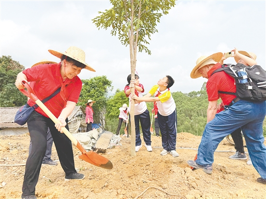 革命先輩后代與學(xué)生代表一起參加義務(wù)植樹活動。
