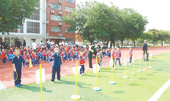 學(xué)生們參加“交通標(biāo)識套圈圈”游戲，在歡聲笑語中將交通規(guī)則牢記心間。