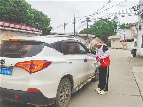 志愿者向過(guò)往車(chē)輛和上山祭掃的群眾發(fā)放文明祭掃倡議書(shū)。