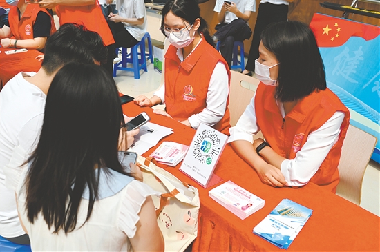 工作人員向市民介紹職工生育保險待遇。