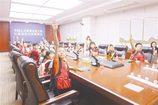 小記者們踴躍舉手參與普法知識(shí)問答。
