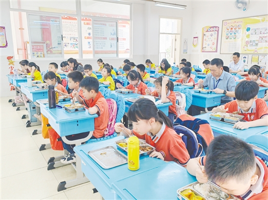 蹲班組成員在教室與學(xué)生一起吃午餐。