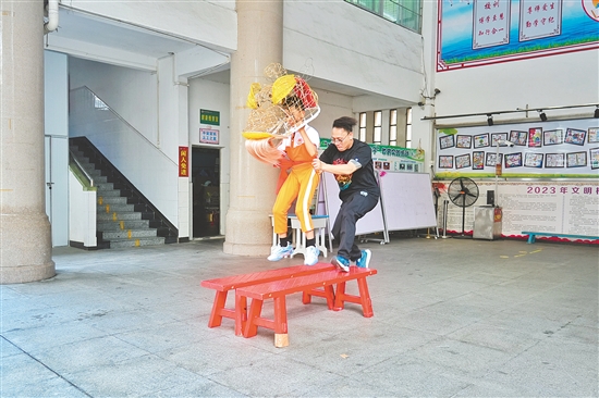馮應(yīng)毅帶領(lǐng)學(xué)生練習(xí)移步、托舉、跳躍等獅藝動作。