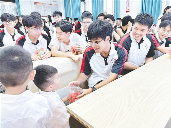 萌娃為高三學(xué)子送上水果。