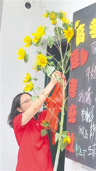 在江海區(qū)禮樂中學考點，該校高三（2）班班主任陳老師特地帶來3株將近2米高的向日葵，祝?？忌耙慌e奪魁”。