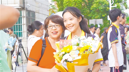 考生捧花與家長合影。