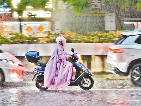連日來(lái)，江門(mén)遭遇強(qiáng)降雨天氣。圖為市民冒雨駕駛摩托車(chē)途經(jīng)蓬江區(qū)東華一路。