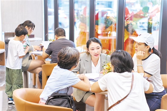 今年國慶假期，全市主要房地產(chǎn)項(xiàng)目認(rèn)購近2300套,圖為銷售人員在接待客人。