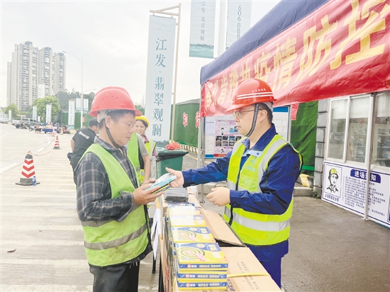 工地施工人員排隊領取防蚊用品。