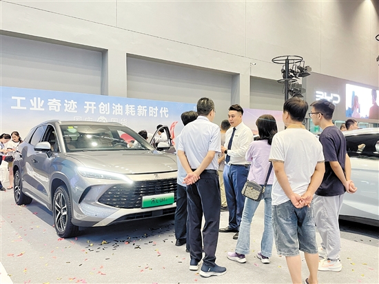 銷售人員向市民講解車型亮點(diǎn)。